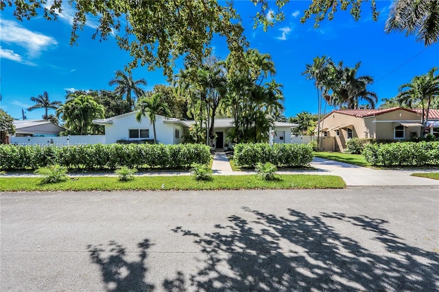 view of front of house featuring stucco siding, a residential view, and fence