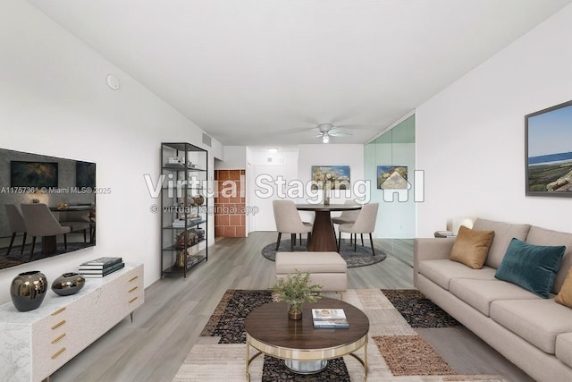 living area featuring a ceiling fan, visible vents, and light wood finished floors