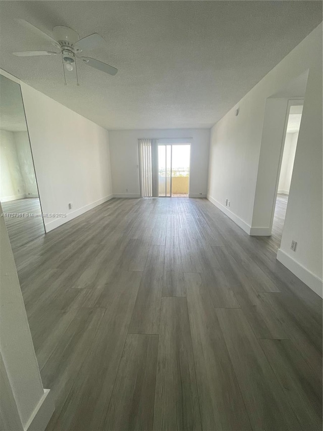 unfurnished room with a ceiling fan, wood finished floors, baseboards, and a textured ceiling