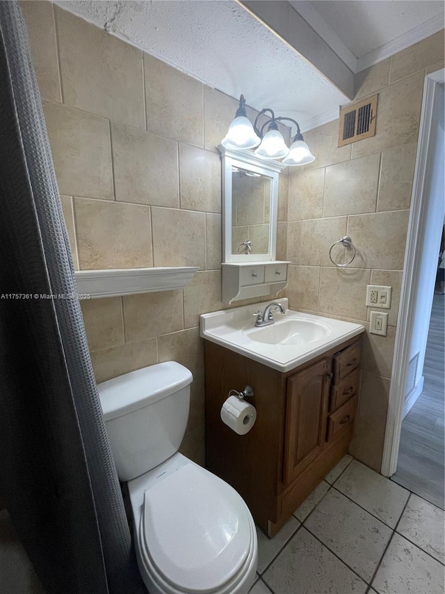 bathroom with visible vents, toilet, tile walls, and vanity