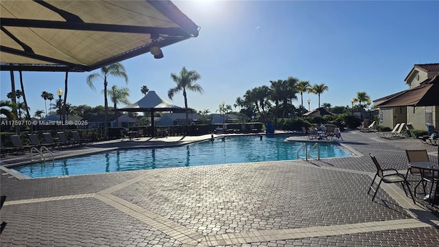 community pool with a patio and fence