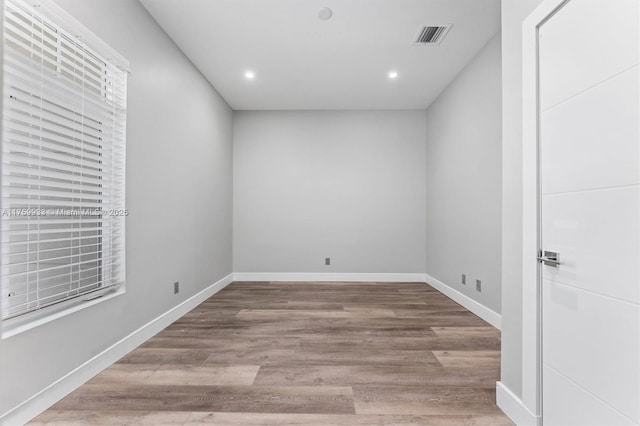 spare room featuring recessed lighting, visible vents, baseboards, and wood finished floors