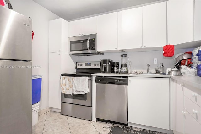 kitchen featuring light countertops, white cabinets, light tile patterned floors, and stainless steel appliances