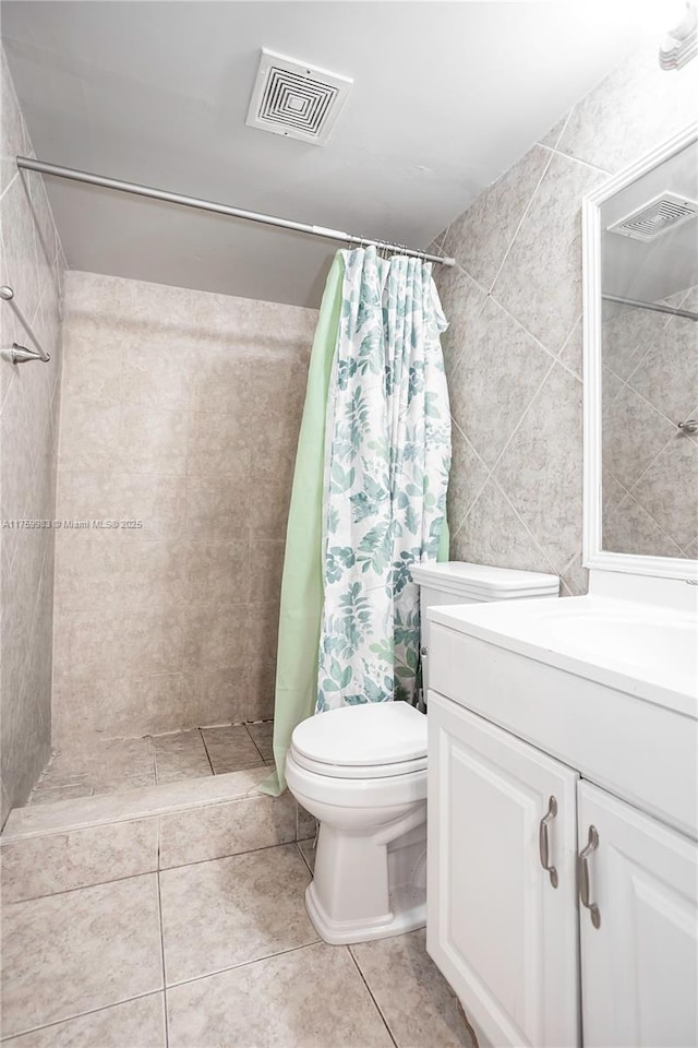 full bathroom featuring visible vents, toilet, a tile shower, tile patterned flooring, and vanity