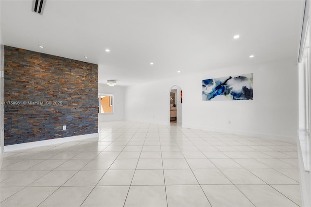 unfurnished room featuring arched walkways, visible vents, recessed lighting, and light tile patterned floors