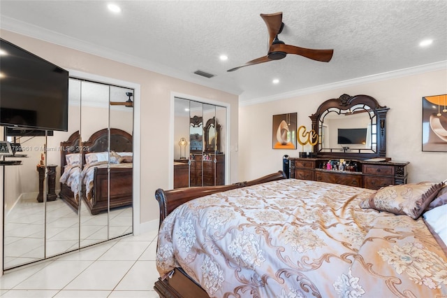 bedroom featuring light tile patterned floors, visible vents, two closets, and crown molding