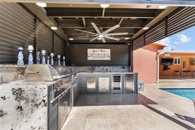 view of patio featuring area for grilling, wine cooler, a ceiling fan, and an outdoor pool