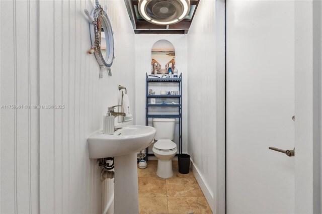 bathroom with tile patterned floors, toilet, and baseboards