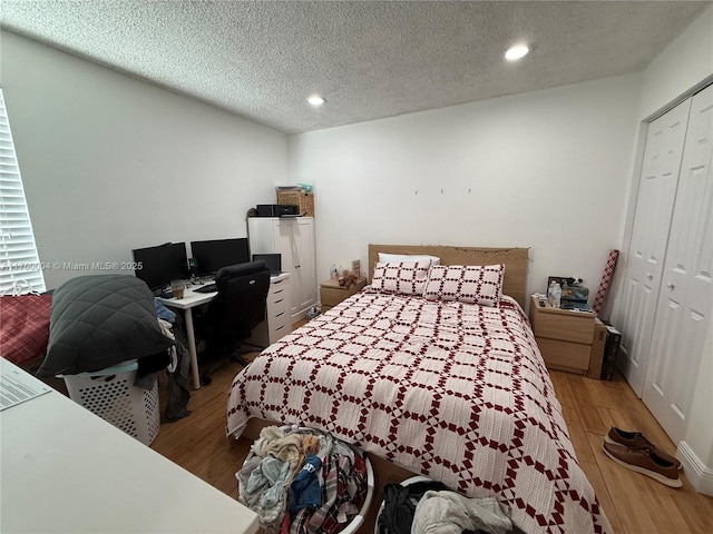 bedroom featuring recessed lighting, wood finished floors, a closet, and a textured ceiling