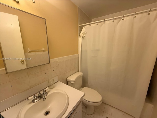 bathroom featuring tile patterned flooring, curtained shower, toilet, vanity, and tile walls