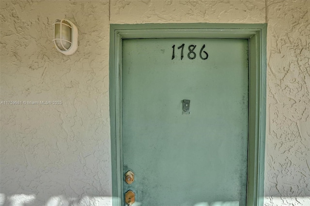 doorway to property featuring stucco siding