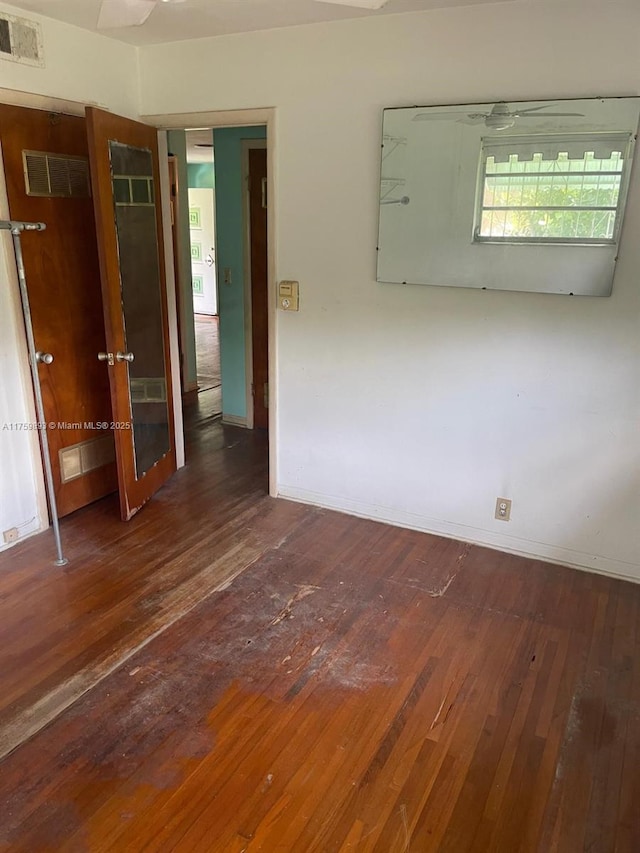 empty room featuring hardwood / wood-style floors and visible vents