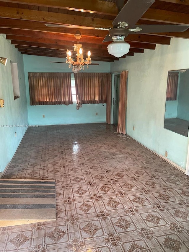 spare room featuring beamed ceiling and a ceiling fan