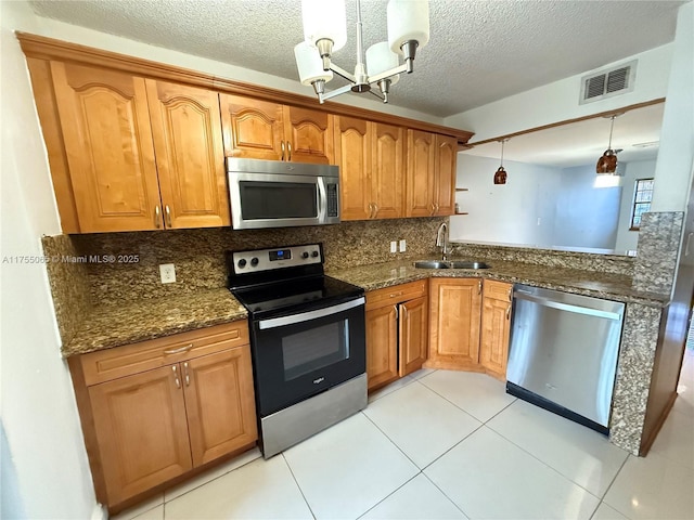 kitchen with visible vents, pendant lighting, a sink, tasteful backsplash, and stainless steel appliances