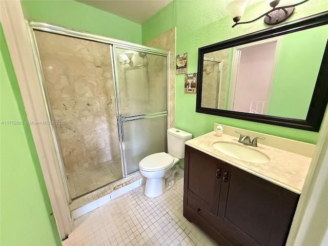 bathroom with tile patterned floors, a shower stall, toilet, and vanity