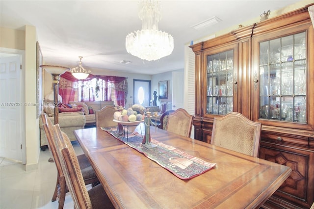 tiled dining space featuring an inviting chandelier