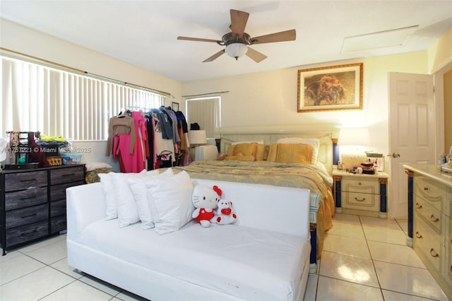 bedroom with attic access, light tile patterned floors, and ceiling fan