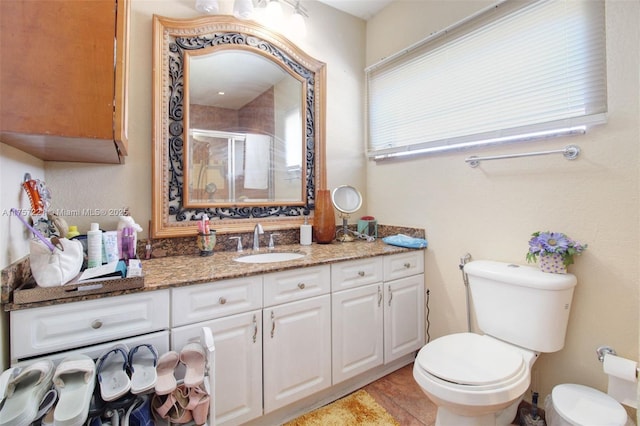 full bathroom featuring vanity, toilet, and a shower stall