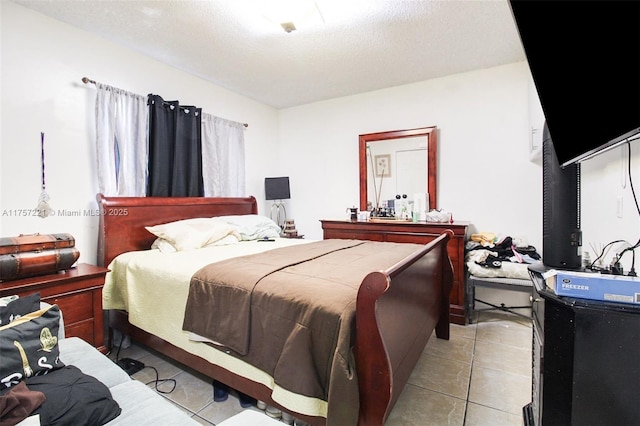 bedroom with light tile patterned floors and a textured ceiling