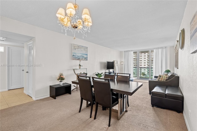 tiled dining room with a chandelier, baseboards, and carpet