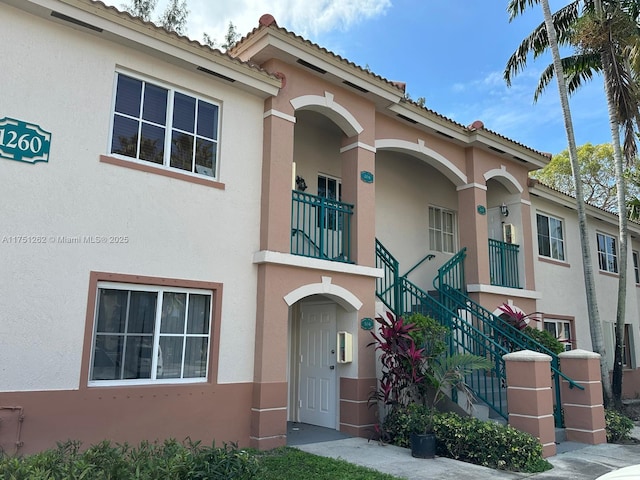 view of front facade with stucco siding and stairs