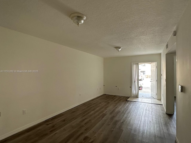 unfurnished room featuring dark wood finished floors, baseboards, and a textured ceiling