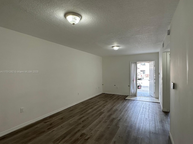 entryway with dark wood finished floors, a textured ceiling, and baseboards