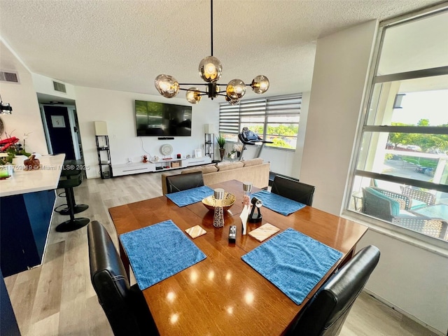 1351 NE Miami Gardens Dr Unit 325E, Miami, FL 33179 - dining area with visible vents, an inviting chandelier, a textured ceiling, and light wood-style floors