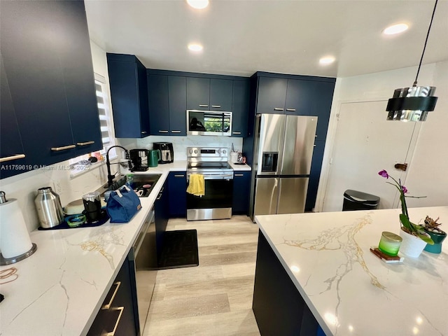 1351 NE Miami Gardens Dr Unit 325E, Miami, FL 33179 - kitchen with light stone countertops, light wood-type flooring, appliances with stainless steel finishes, and a sink