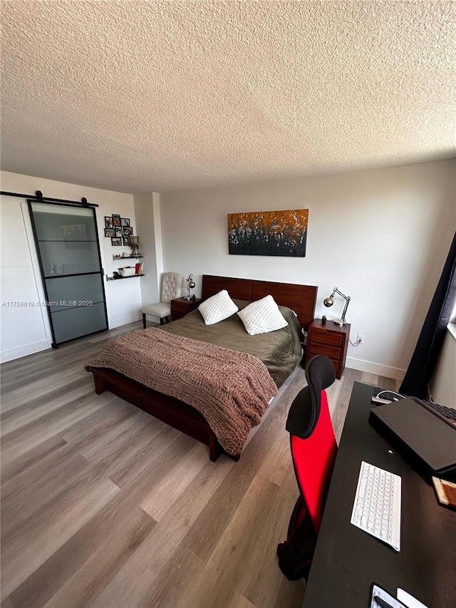 1351 NE Miami Gardens Dr Unit 325E, Miami, FL 33179 - bedroom with a textured ceiling, baseboards, and wood finished floors