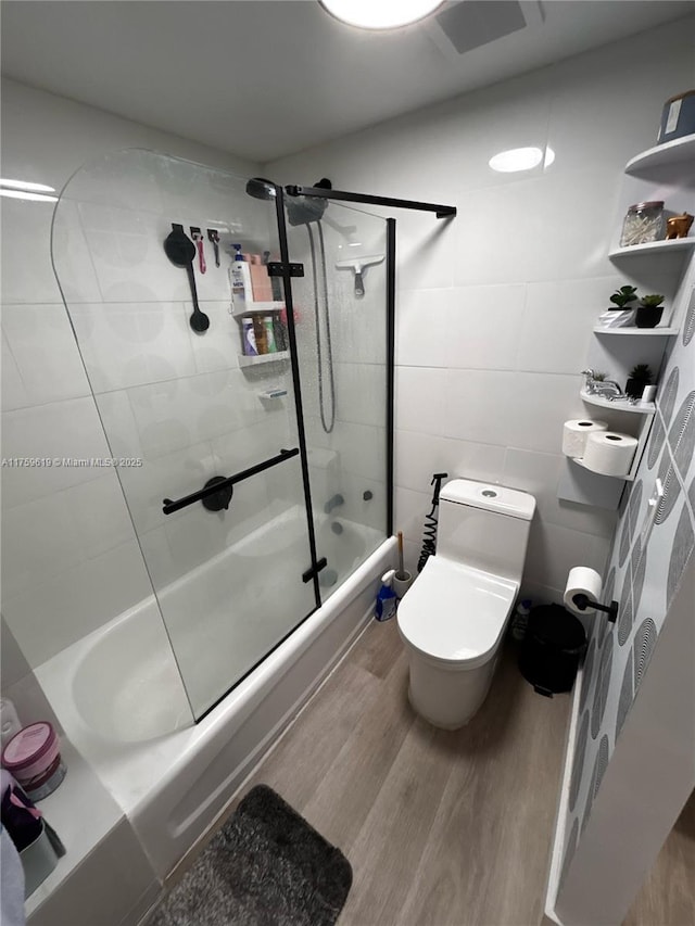 1351 NE Miami Gardens Dr Unit 325E, Miami, FL 33179 - bathroom featuring toilet, shower / bath combination with glass door, tile walls, and wood finished floors