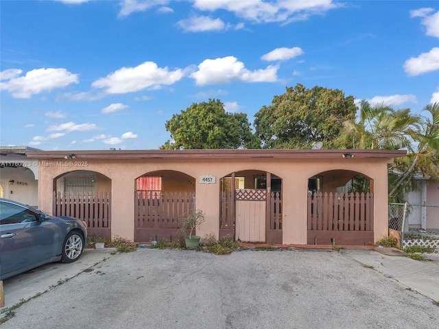 view of front of home featuring stucco siding and fence