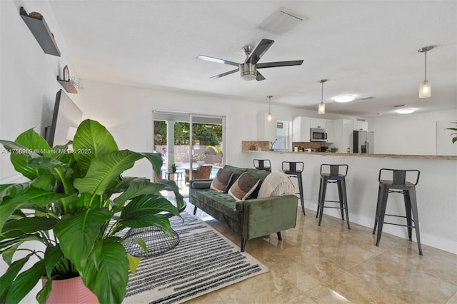 living area with visible vents, baseboards, and a ceiling fan