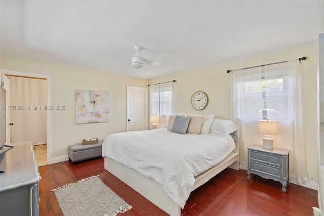 bedroom with dark wood-type flooring and baseboards