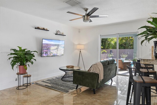 living area with visible vents, baseboards, and a ceiling fan