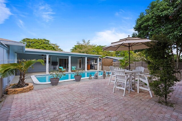 view of swimming pool with a patio, fence, a fenced in pool, outdoor dining area, and ceiling fan