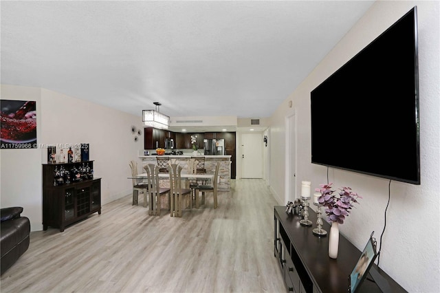 living area with baseboards and light wood finished floors