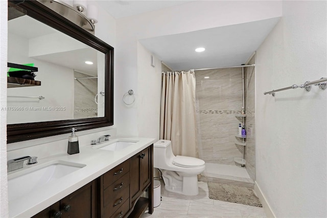 bathroom with toilet, tiled shower, and a sink