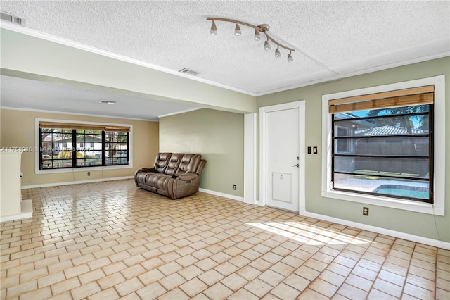 unfurnished room featuring visible vents, a textured ceiling, baseboards, and ornamental molding