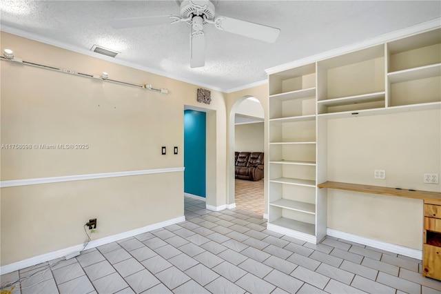 empty room with visible vents, baseboards, arched walkways, a textured ceiling, and a ceiling fan