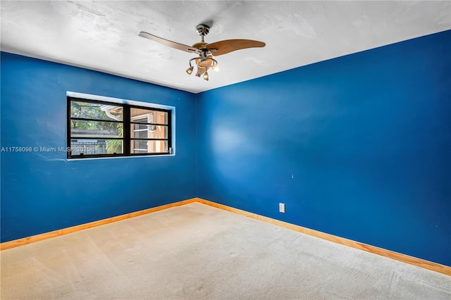 empty room featuring a ceiling fan, baseboards, and carpet floors