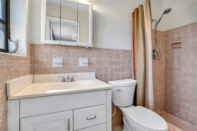 bathroom with vanity, a stall shower, wainscoting, tile walls, and toilet