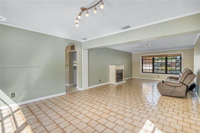 unfurnished living room with visible vents, a fireplace with raised hearth, ornamental molding, arched walkways, and a textured ceiling