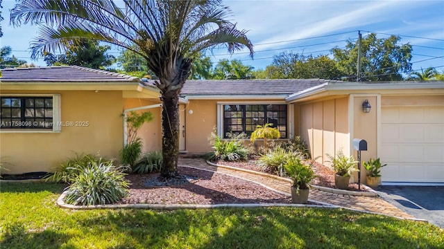 ranch-style home featuring a tile roof, a garage, and stucco siding