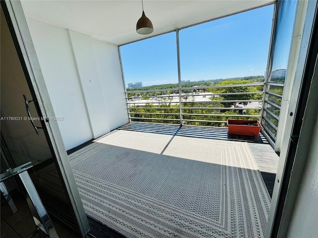 unfurnished sunroom featuring a view of city and plenty of natural light