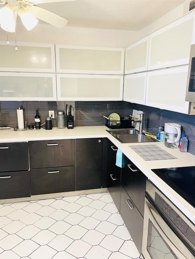 kitchen with visible vents, a sink, stainless steel appliances, light countertops, and backsplash