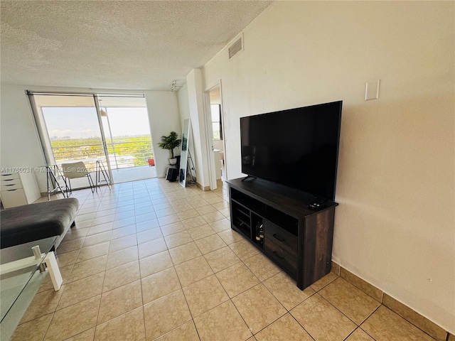 3660 NE 166th St Unit 812, North Miami Beach, FL 33160 - living room featuring a textured ceiling, light tile patterned floors, and baseboards