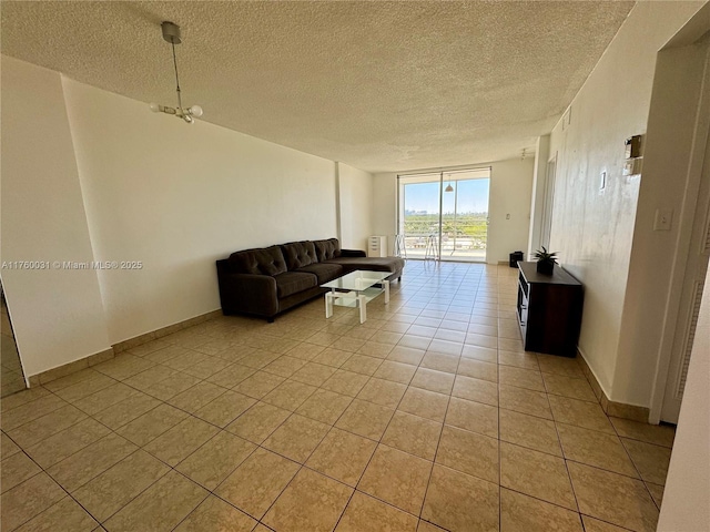 living room featuring light tile patterned floors, a textured ceiling, and baseboards