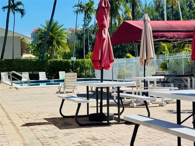 view of community with a patio, a pool, and fence