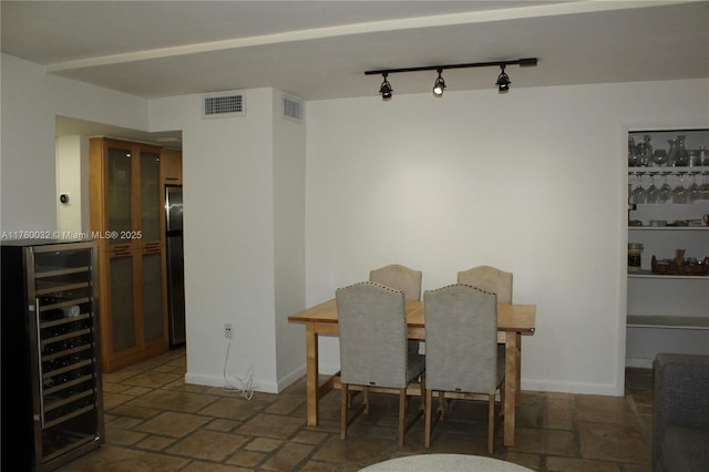 dining room with visible vents, baseboards, and beverage cooler